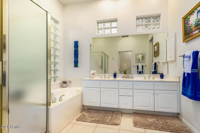 a spacious bathroom with a bathtub sink and mirror