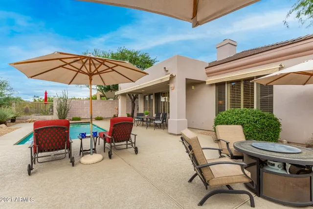 a view of a patio with a table and chairs under an umbrella