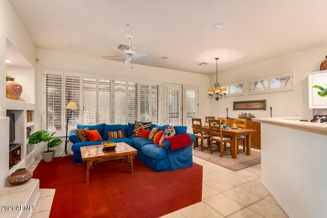 a living room with furniture kitchen view and a large window