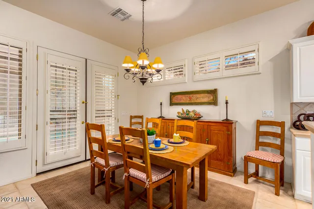 a dining room with furniture a chandelier and window
