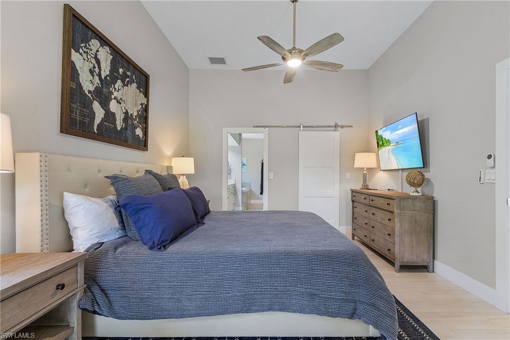 7596 San Miguel Way Naples, FL 34109 - Photo 34 of 34 a bedroom with a bed and a chandelier