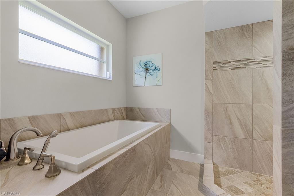 7596 San Miguel Way Naples, FL 34109 - Photo 16 of 34 a bathroom with a tub and a window