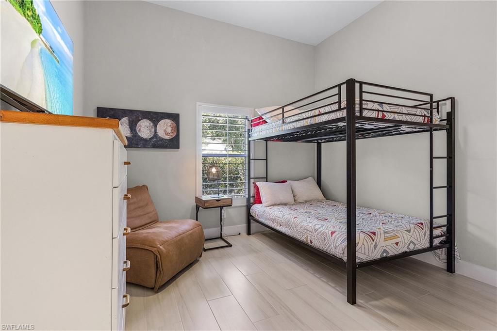 7596 San Miguel Way Naples, FL 34109 - Photo 19 of 34 a bedroom with a bed and a chandelier