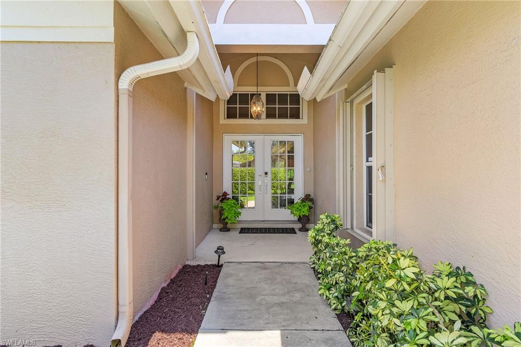 7596 San Miguel Way Naples, FL 34109 - Photo 2 of 34 a front view of a house with a yard and flowers