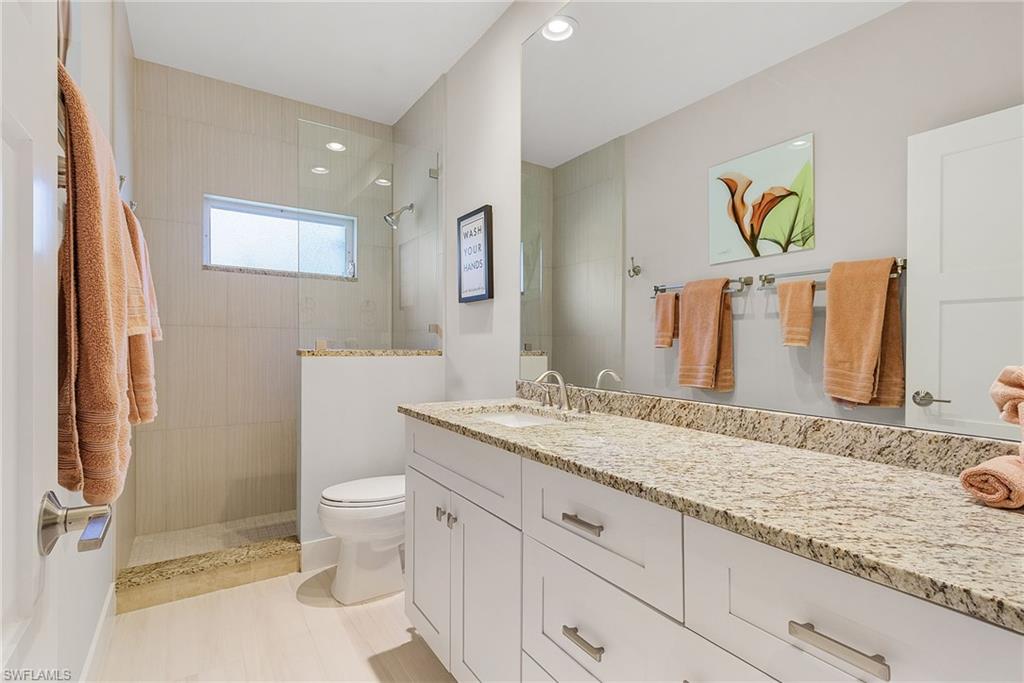 7596 San Miguel Way Naples, FL 34109 - Photo 20 of 34 a bathroom with a granite countertop sink and a mirror