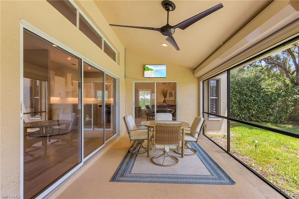 7596 San Miguel Way Naples, FL 34109 - Photo 23 of 34 a dining room with wooden floor and a rug