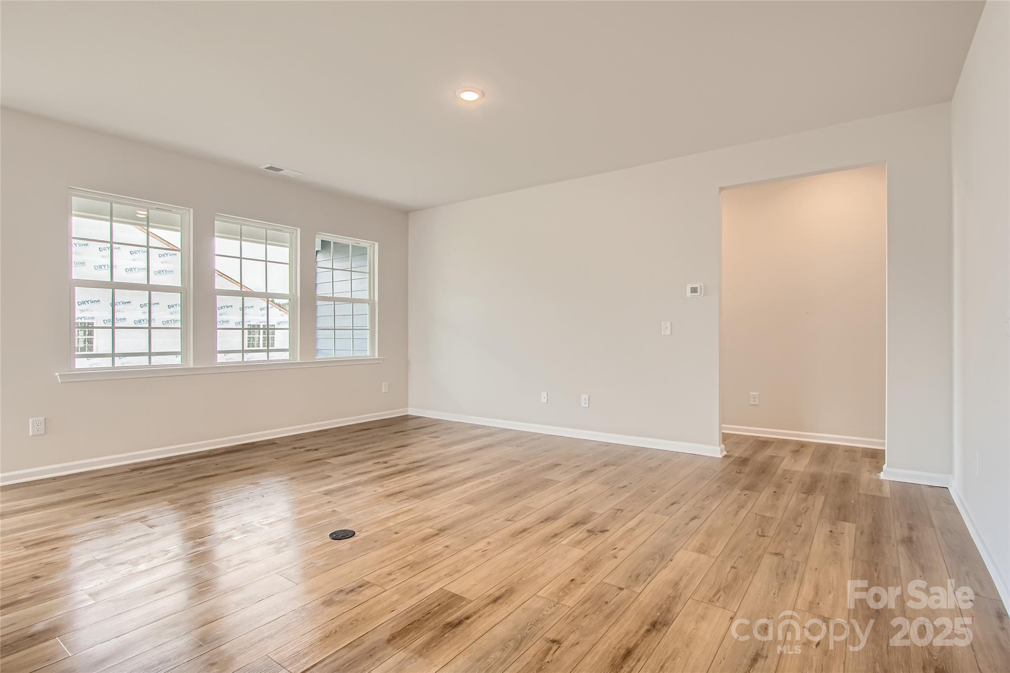 8454 Norman Frst Road Lancaster, SC 29720 - Photo 3 of 16 an empty room with wooden floor and windows
