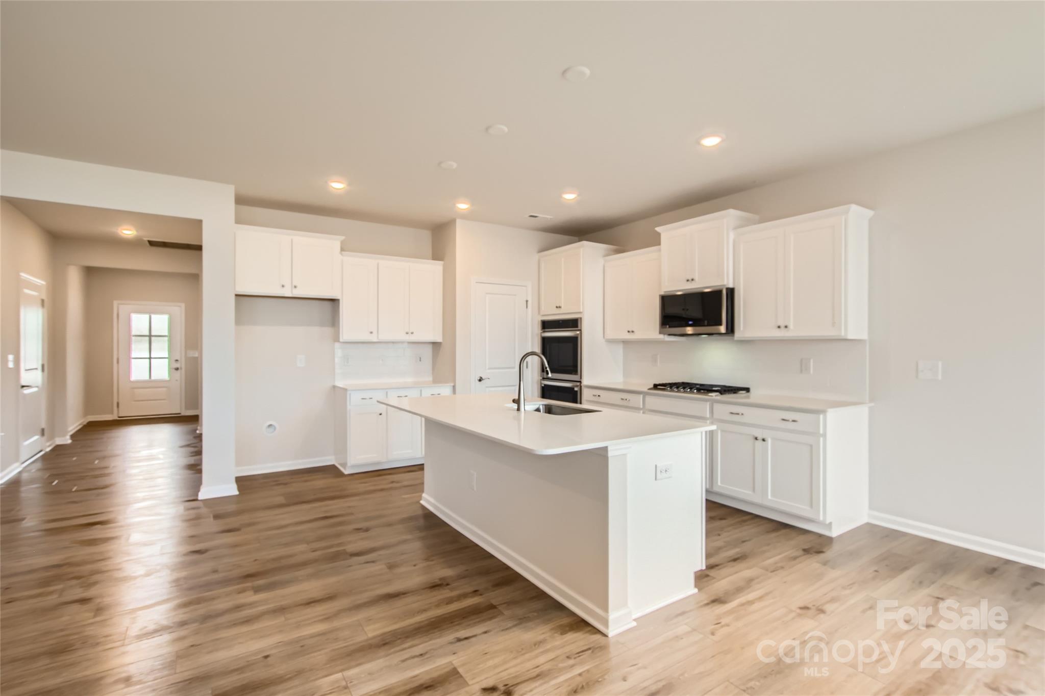 8454 Norman Frst Road Lancaster, SC 29720 - Photo 5 of 16 a kitchen with stainless steel appliances a white cabinets and wooden floor