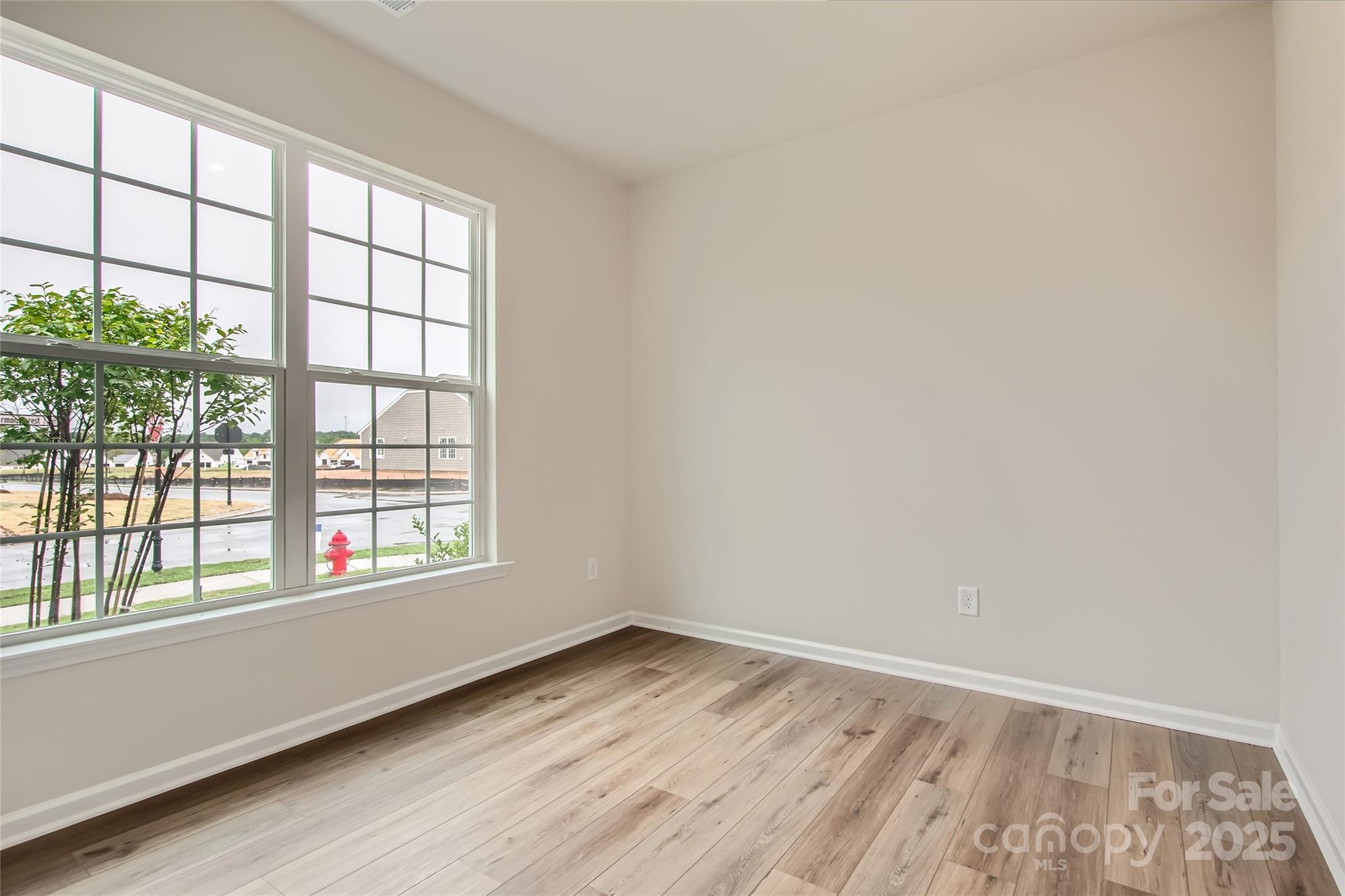 8454 Norman Frst Road Lancaster, SC 29720 - Photo 9 of 16 an empty room with wooden floor and windows
