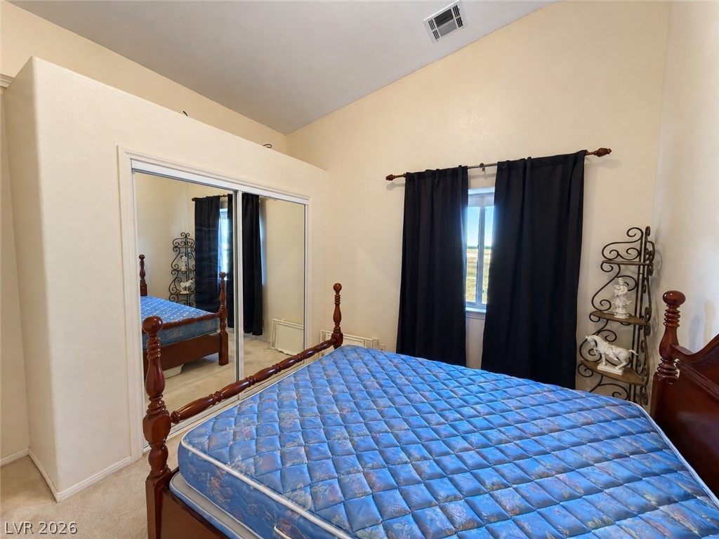 5470 Grain Mill Road Pahrump, NV 89061 - Photo 44 of 80 High ceilings and a large mirrored closet door enhance this cozy bedroom space.