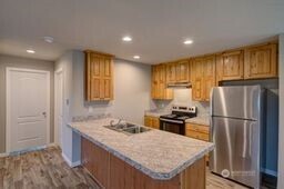 1331 Dolan Street Raymond, WA 98577 - Photo 14 of 32 a kitchen with granite countertop kitchen island wooden cabinets a refrigerator stove sink and cabinets