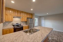 1331 Dolan Street Raymond, WA 98577 - Photo 15 of 32 a kitchen with kitchen island granite countertop a sink stove and refrigerator