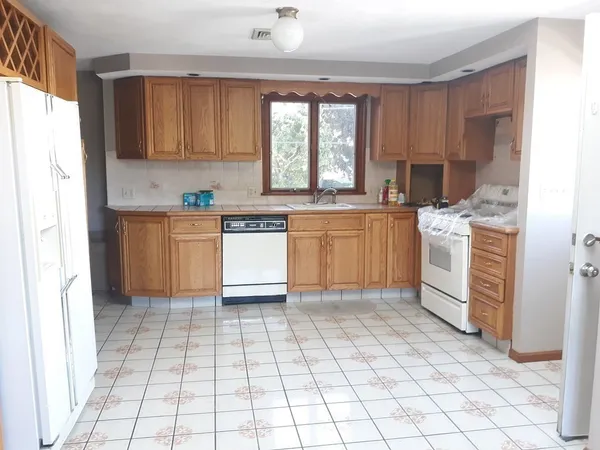 a kitchen with stainless steel appliances granite countertop a stove a sink and a refrigerator