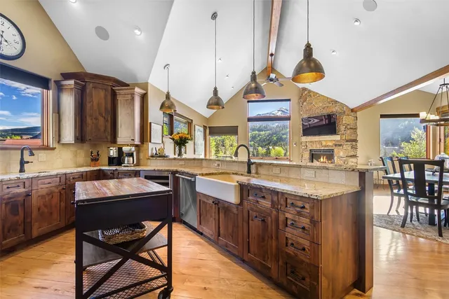 a kitchen with stainless steel appliances granite countertop a table chairs and a sink