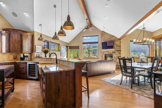 a kitchen with stainless steel appliances granite countertop a sink a stove and a wooden floors