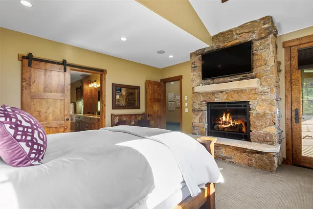 a spacious bedroom with a bed and a flat screen tv