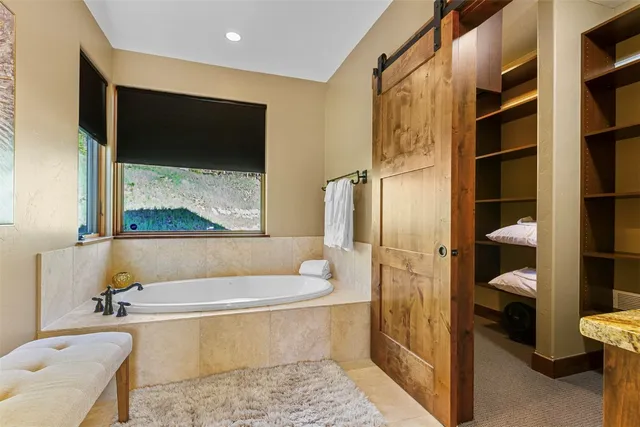 a bathroom with a tub a toilet and a shower