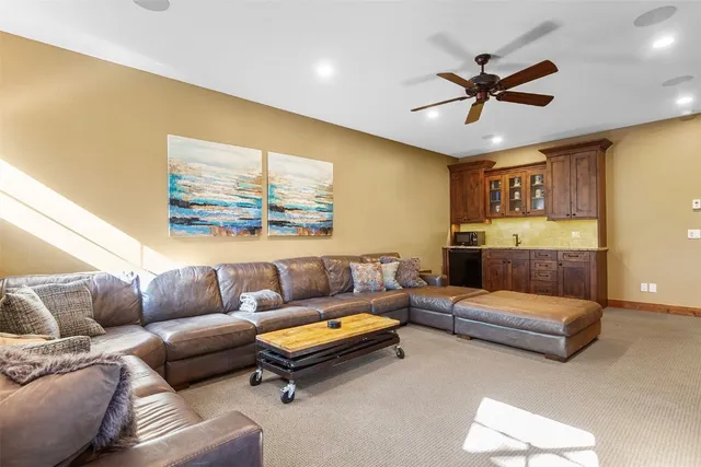 a living room with furniture and a ceiling fan