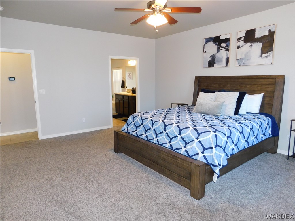 3370 South Ridge Avenue Bullhead City, AZ 86429 - Photo 36 of 56 a large bed sitting in a bedroom next to a lamp and a chandelier
