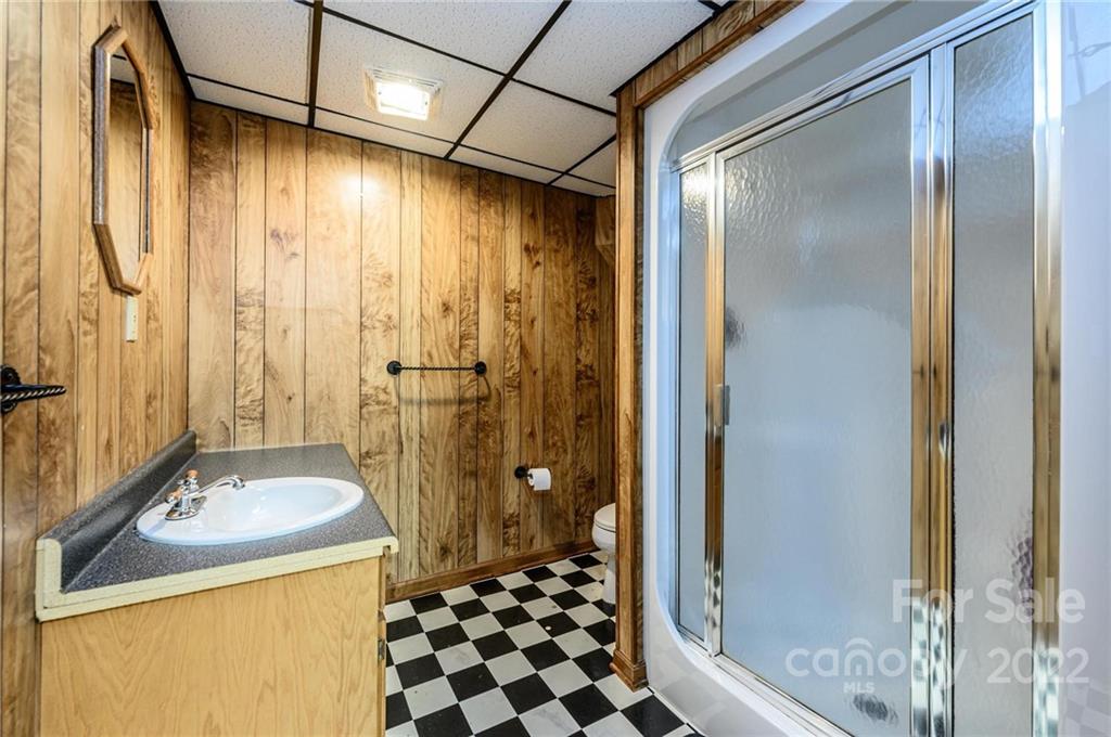 6265 Oxford School Road Claremont, NC 28610 - Photo 22 of 30 a bathroom with a sink a mirror and a shower