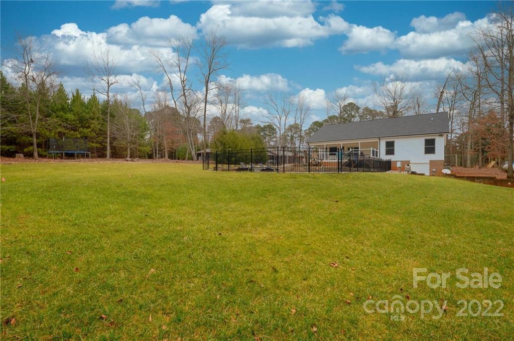 6265 Oxford School Road Claremont, NC 28610 - Photo 27 of 30 a view of a large pool with lawn chairs and large trees