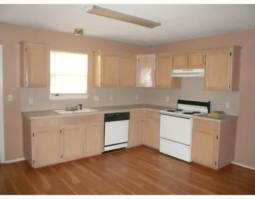 a kitchen with granite countertop white cabinets and white appliances