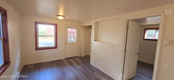 a view of hallway with a closet and a window
