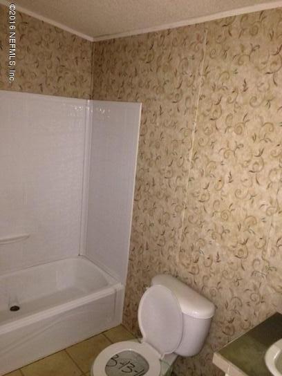 7820 Ranchette Road Keystone Heights, FL 32656 - Photo 14 of 19 a bathroom with a toilet and a bathtub