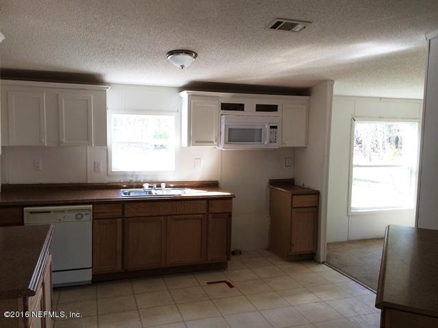 7820 Ranchette Road Keystone Heights, FL 32656 - Photo 2 of 19 a kitchen with a sink window and cabinets