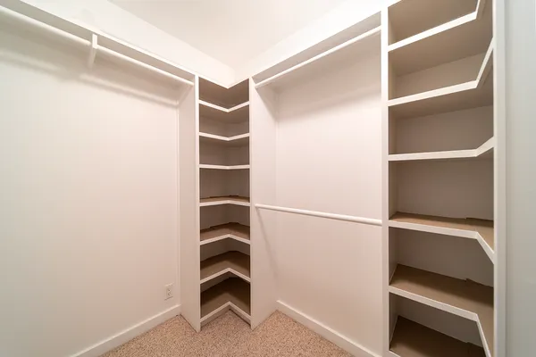 a view of walk in closet with empty racks