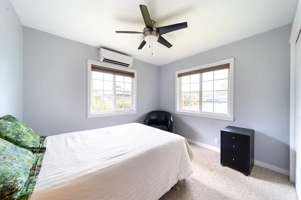 a bedroom with a bed and a large window