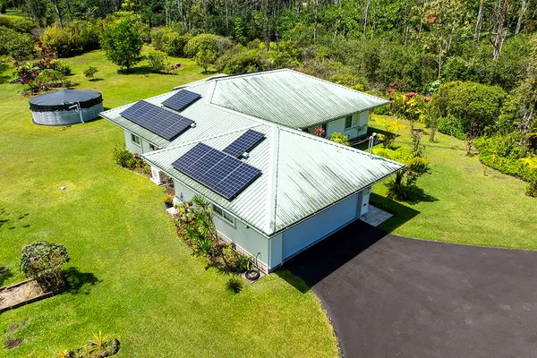 an aerial view of residential houses with outdoor space and trees