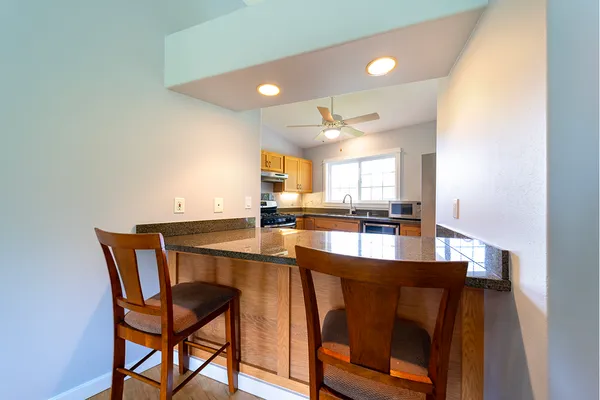 a dining hall with stainless steel appliances a dining table and chairs with wooden floor