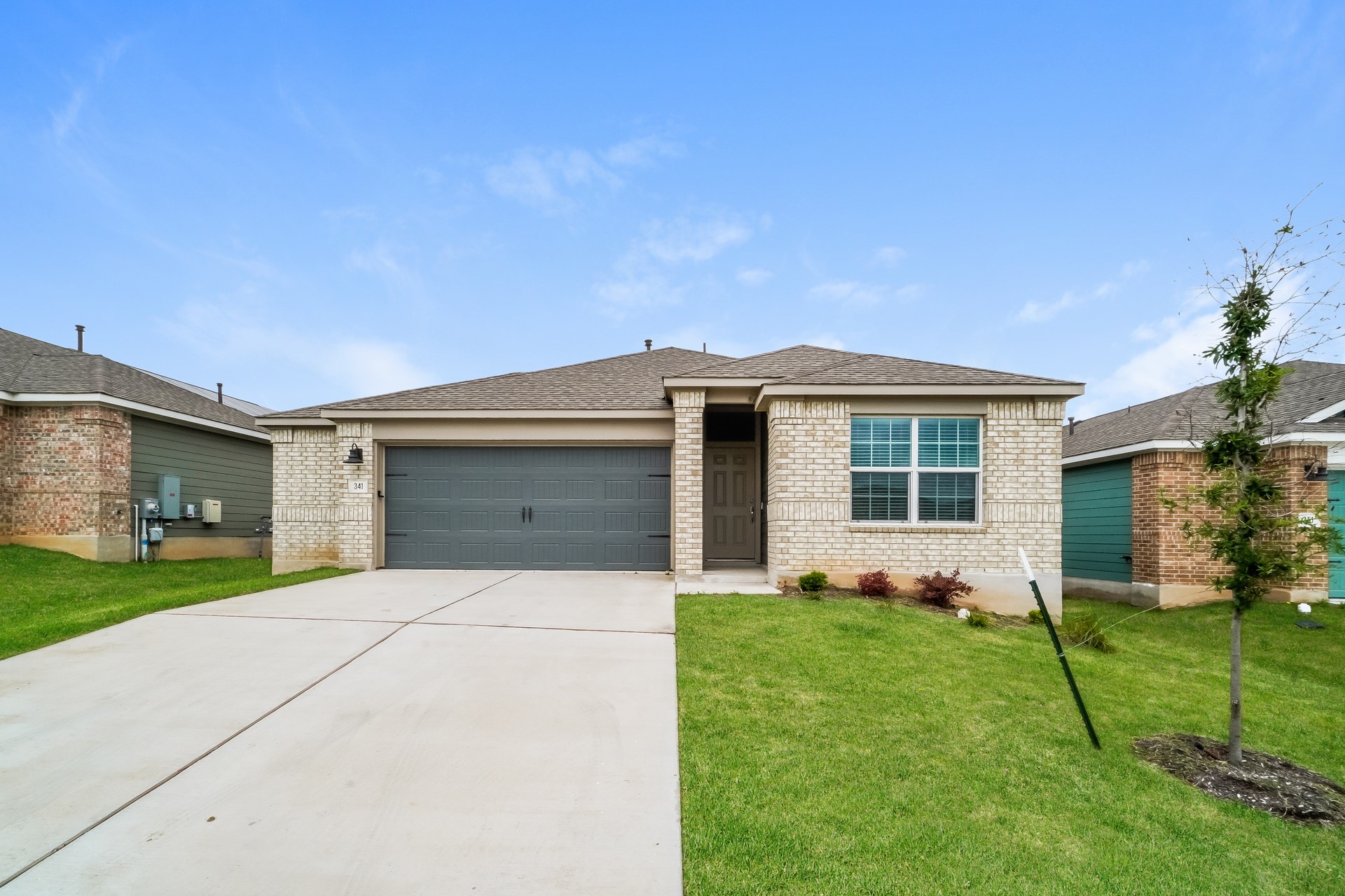 341 Madrid Kyle, TX 78640 - Photo 1 of 27 A well-maintained facade with brick construction and an integrated garage presents inviting curb appeal.