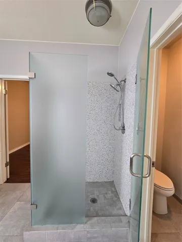a bathroom with a granite countertop shower and a toilet