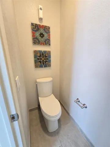 a white toilet sitting next to a shower