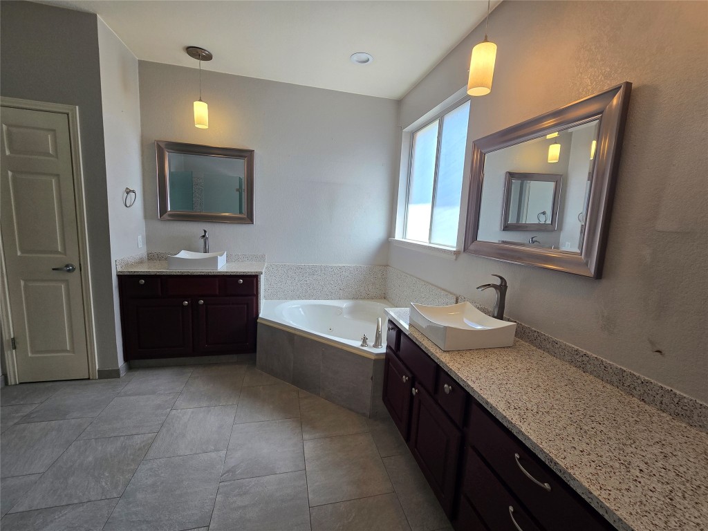 2216 Shark Loop Round Rock, TX 78664 - Photo 21 of 27 a spacious bathroom with a granite countertop sink and a mirror