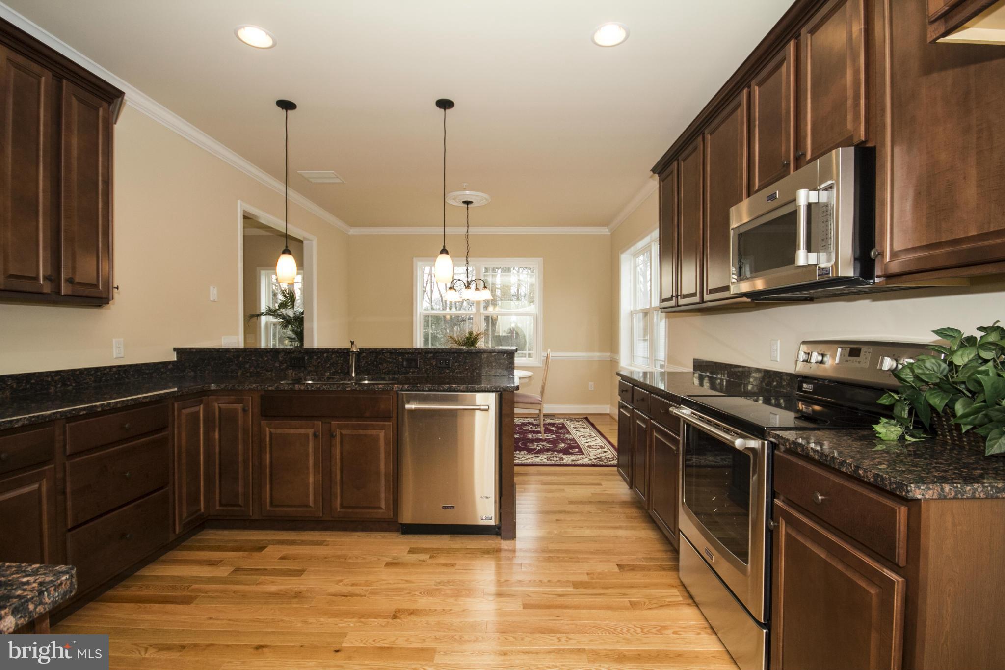254 Nanticoke Road Baltimore, MD 21221 - Photo 12 of 30 a kitchen with stainless steel appliances granite countertop a sink a stove and a wooden floors