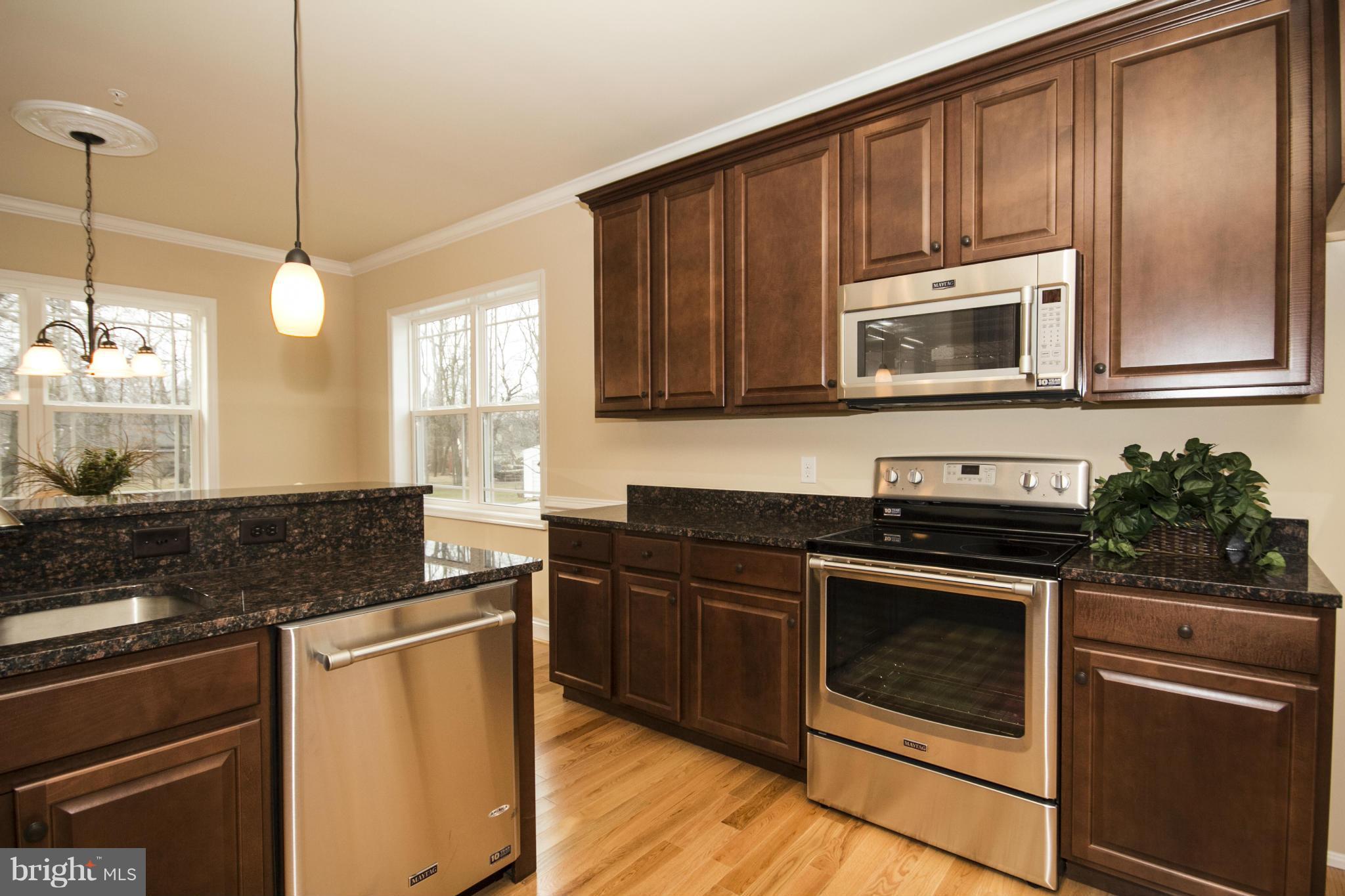 254 Nanticoke Road Baltimore, MD 21221 - Photo 14 of 30 a kitchen with granite countertop wooden cabinets and stainless steel appliances