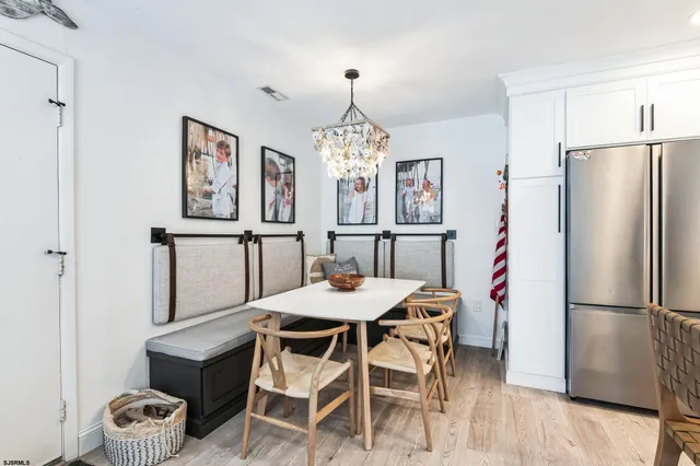 a dining room with furniture a chandelier and wooden floor
