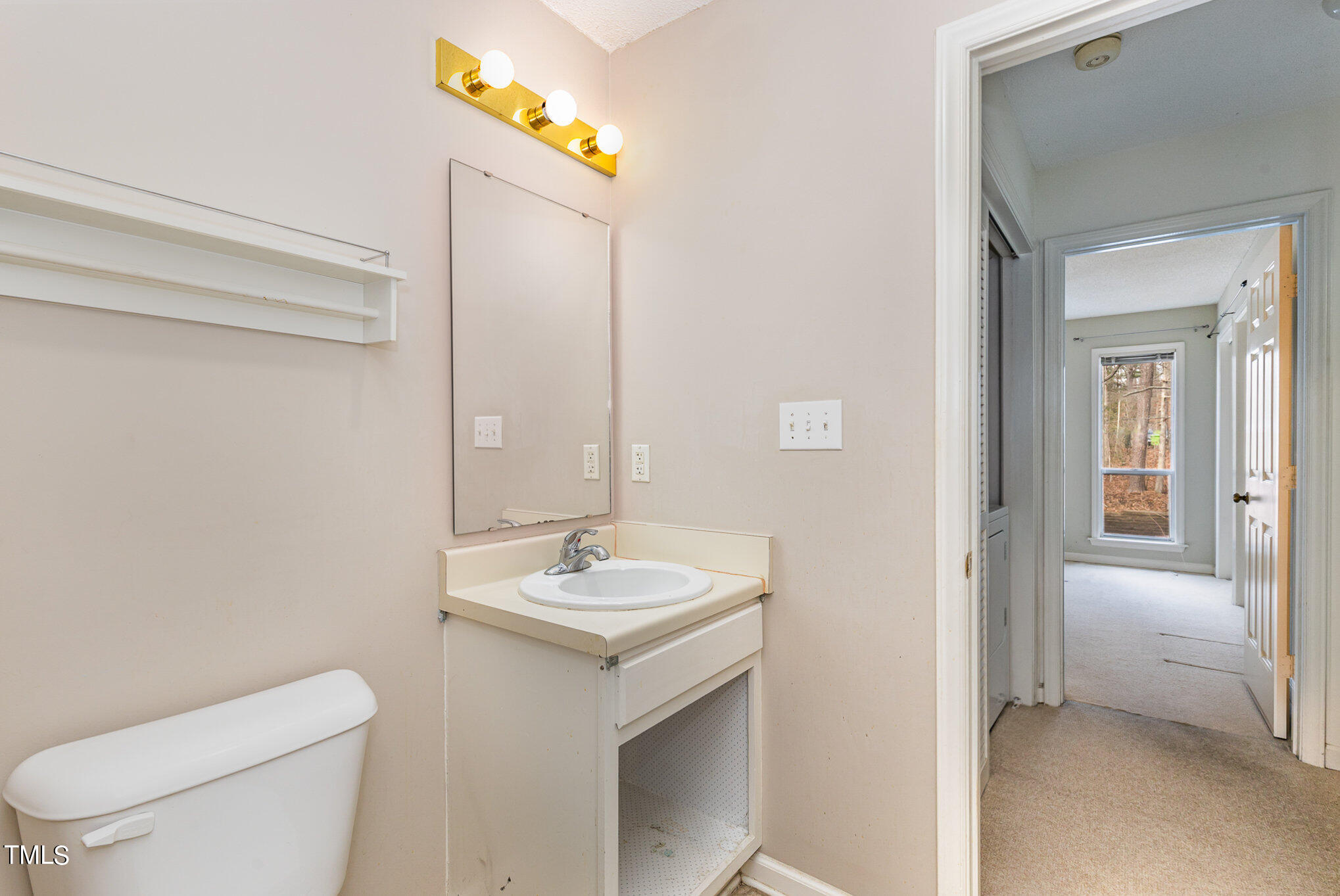 4631 Timbermill Court, Unit 303 Raleigh, NC 27612 - Photo 14 of 15 a bathroom with a toilet a sink and mirror