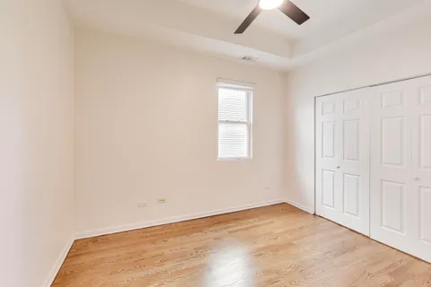 an empty room with ceiling fan and window