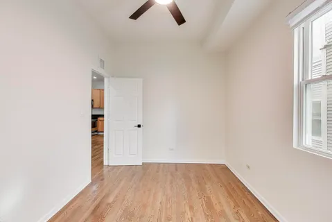 an empty room with ceiling fan and window