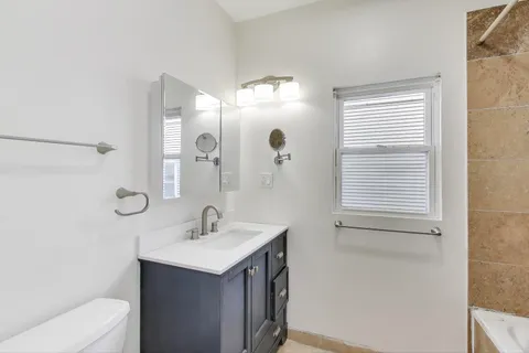 a bathroom with a sink a toilet and a mirror