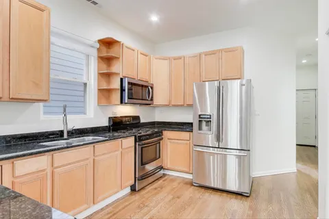 a kitchen with stainless steel appliances a refrigerator sink and microwave