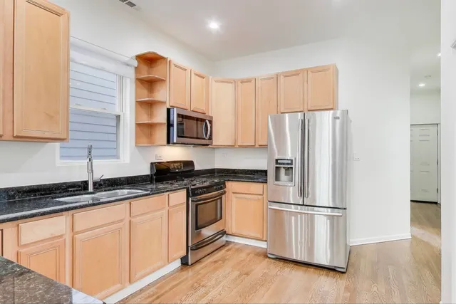 a kitchen with stainless steel appliances a refrigerator sink and microwave