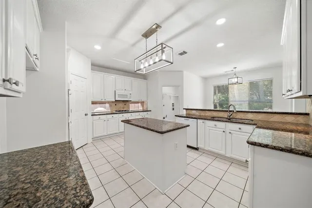 a kitchen with white cabinets and white appliances
