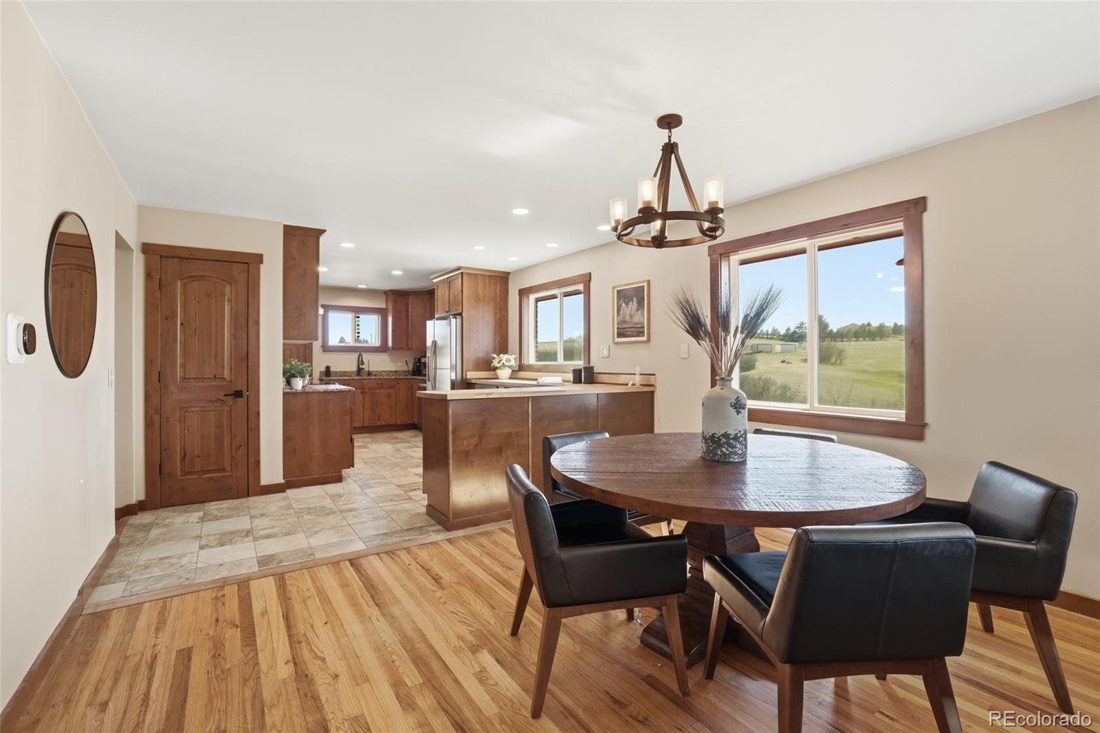 2097 West Wolfensberger Road Castle Rock, CO 80109 - Photo 12 of 48 a dining room with furniture a chandelier and wooden floor