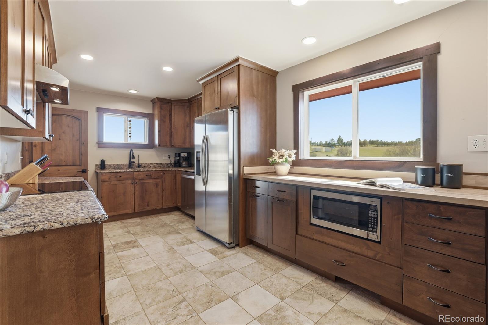 2097 West Wolfensberger Road Castle Rock, CO 80109 - Photo 14 of 48 a kitchen with stainless steel appliances granite countertop a stove a sink and a refrigerator