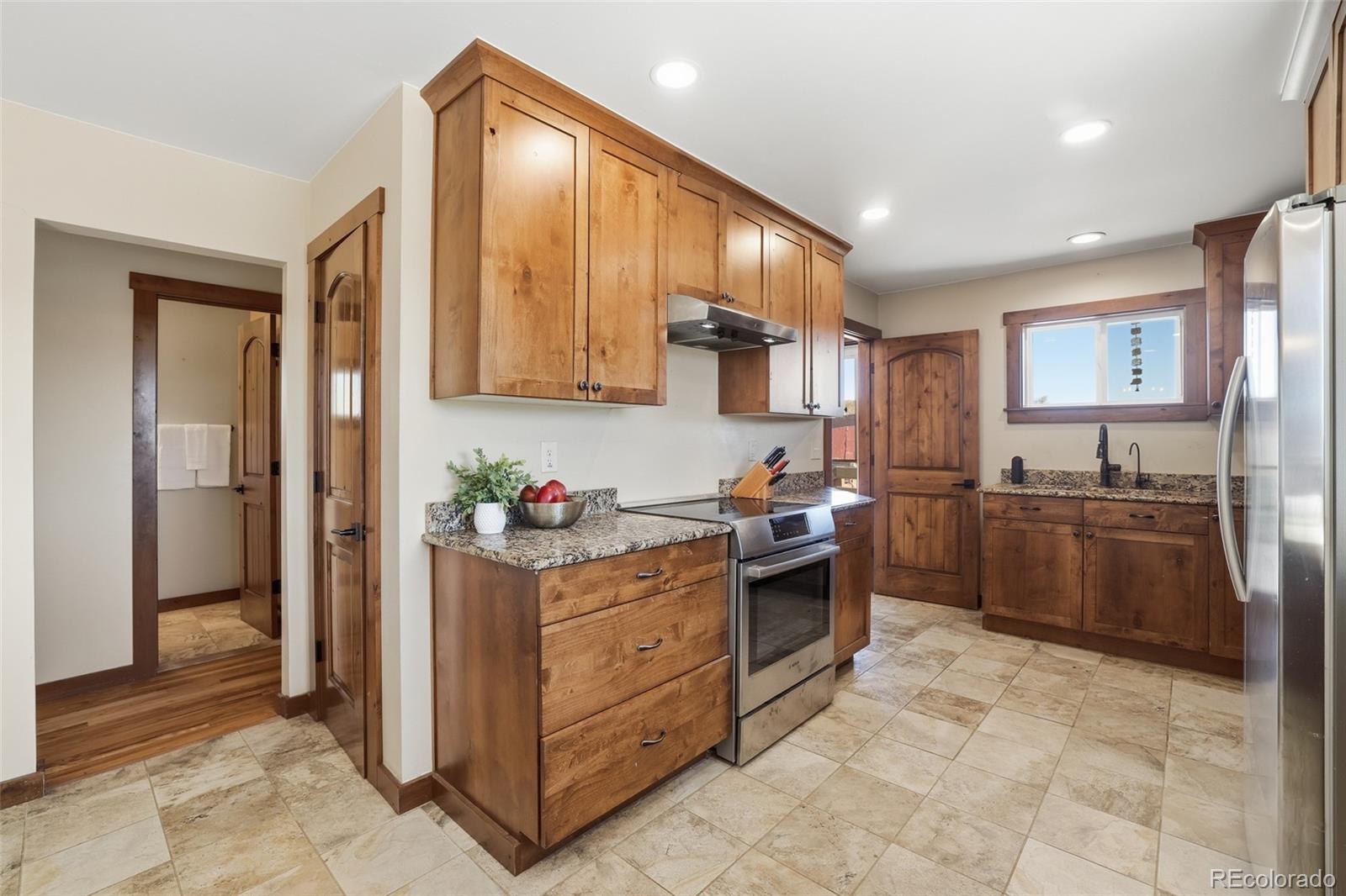 2097 West Wolfensberger Road Castle Rock, CO 80109 - Photo 15 of 48 a kitchen with stainless steel appliances granite countertop a stove a sink and a refrigerator